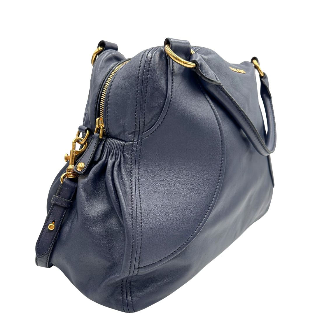 lato Borsa Miu Miu in pelle blu con parti metalliche dorate; munita di una tracolla amovibile e doppi manici stondati. Completa di dustbag, di lusso, originale, ottime condizioni. 