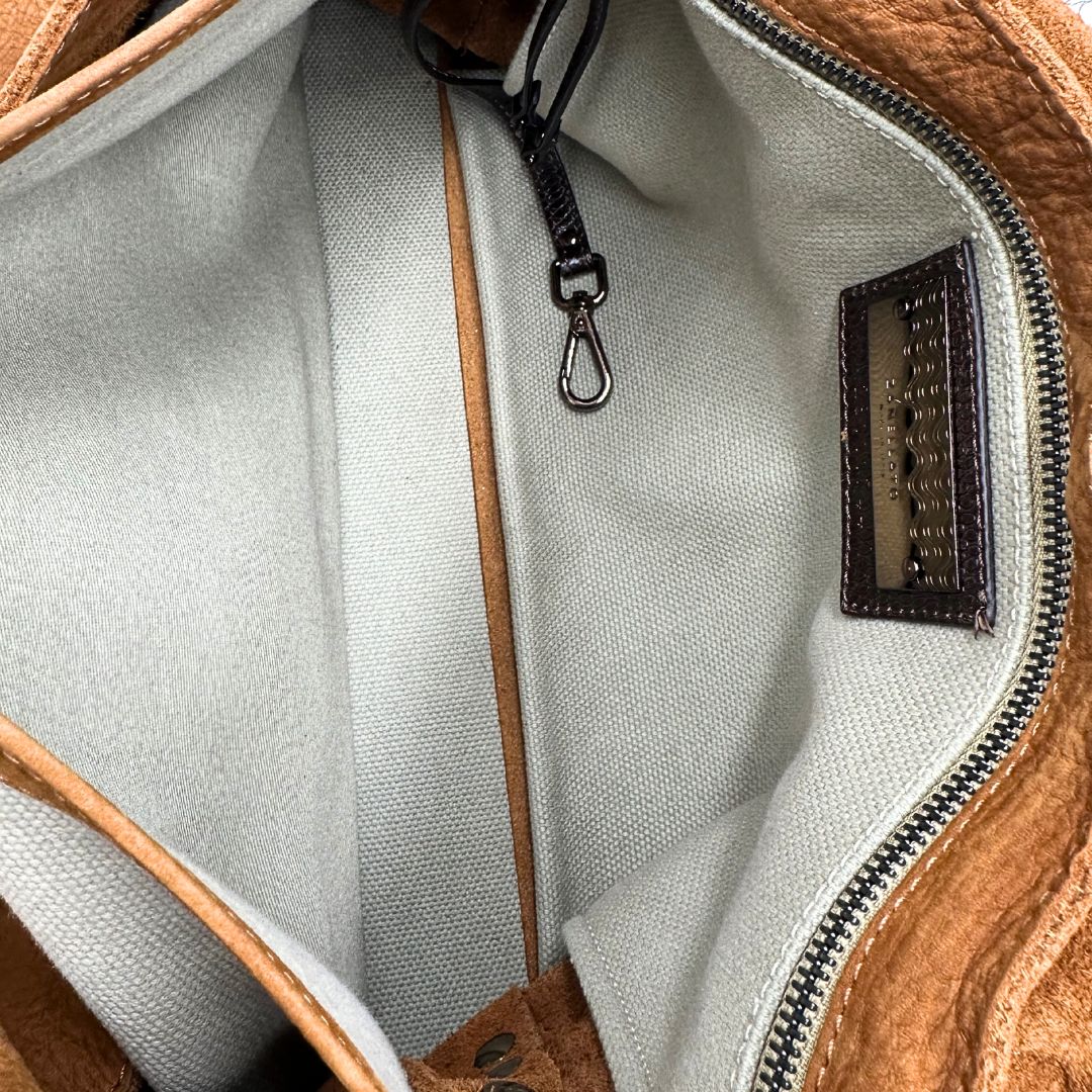 Interno di una borsa Postina M Zanellato in pelle scamosciata color cannella con finiture marroni testa di moro e parti metalliche bronzo; munita di un manico singolo . Completa di dustbag.