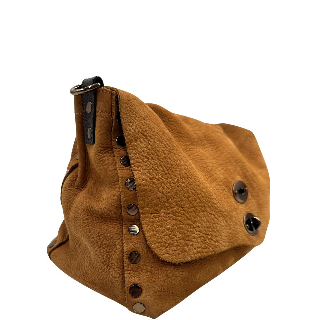 Laterale sinistro di una borsa Postina M Zanellato in pelle scamosciata color cannella con finiture marroni testa di moro e parti metalliche bronzo; munita di un manico singolo . Completa di dustbag.