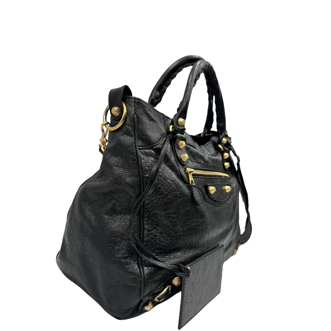 lato Borsa Balenciaga in pelle crinkled nera con parti metalliche dorate; munita di doppi manici stondati con trama a intreccio e una tracolla amovibile e regolabile. Completa di dustbag, di lusso, originale, ottime condizioni