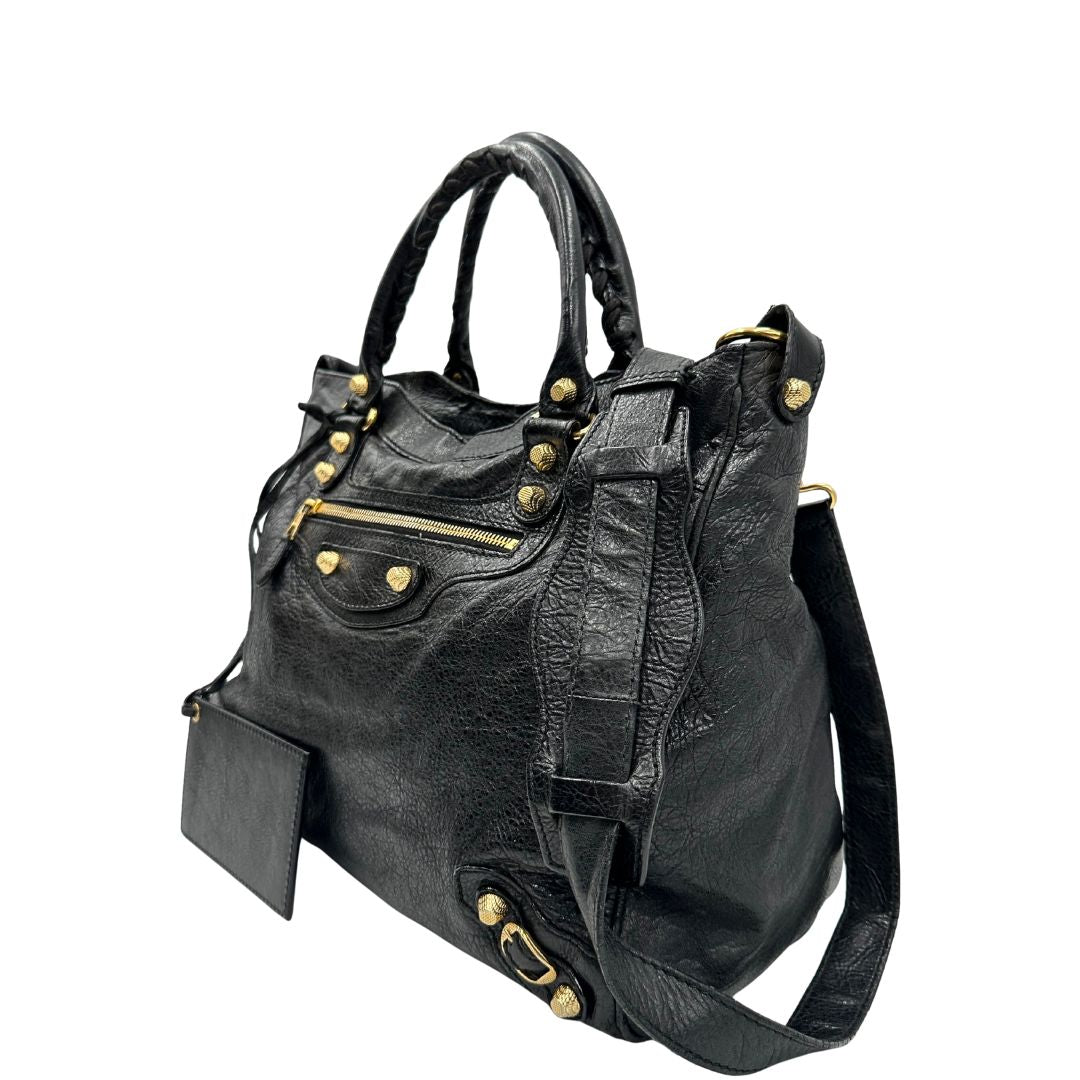 lato Borsa Balenciaga in pelle crinkled nera con parti metalliche dorate; munita di doppi manici stondati con trama a intreccio e una tracolla amovibile e regolabile. Completa di dustbag, di lusso, originale, ottime condizioni 