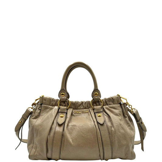 front Borsa Miu Miu in pelle beige con parti metalliche dorate; munita di una tracolla e doppi manici stondati. Completa di dustbag, di lusso, originale, ottime condizioni. 