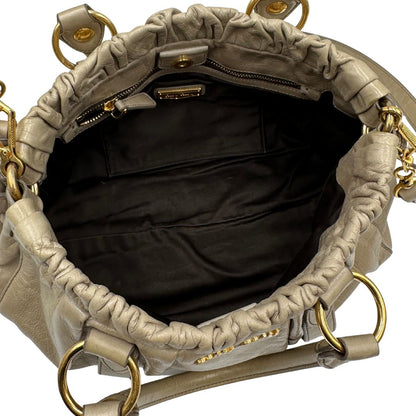 interno Borsa Miu Miu in pelle beige con parti metalliche dorate; munita di una tracolla e doppi manici stondati. Completa di dustbag, di lusso, originale, ottime condizioni.
