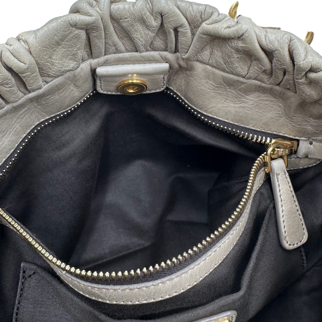 interno Borsa Miu Miu in pelle beige con parti metalliche dorate; munita di una tracolla e doppi manici stondati. Completa di dustbag, di lusso, originale, ottime condizioni.