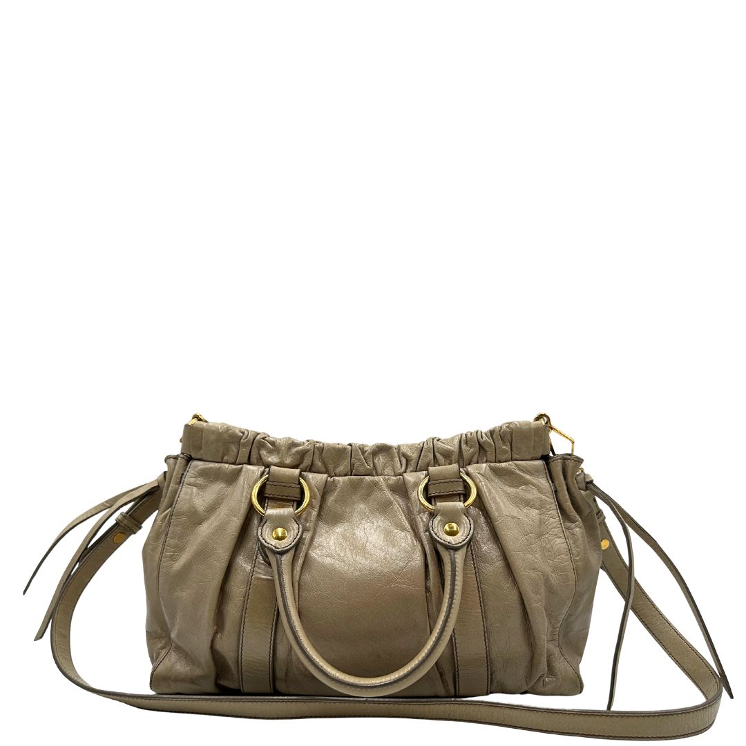 retro Borsa Miu Miu in pelle beige con parti metalliche dorate; munita di una tracolla e doppi manici stondati. Completa di dustbag, di lusso, originale, ottime condizioni. 