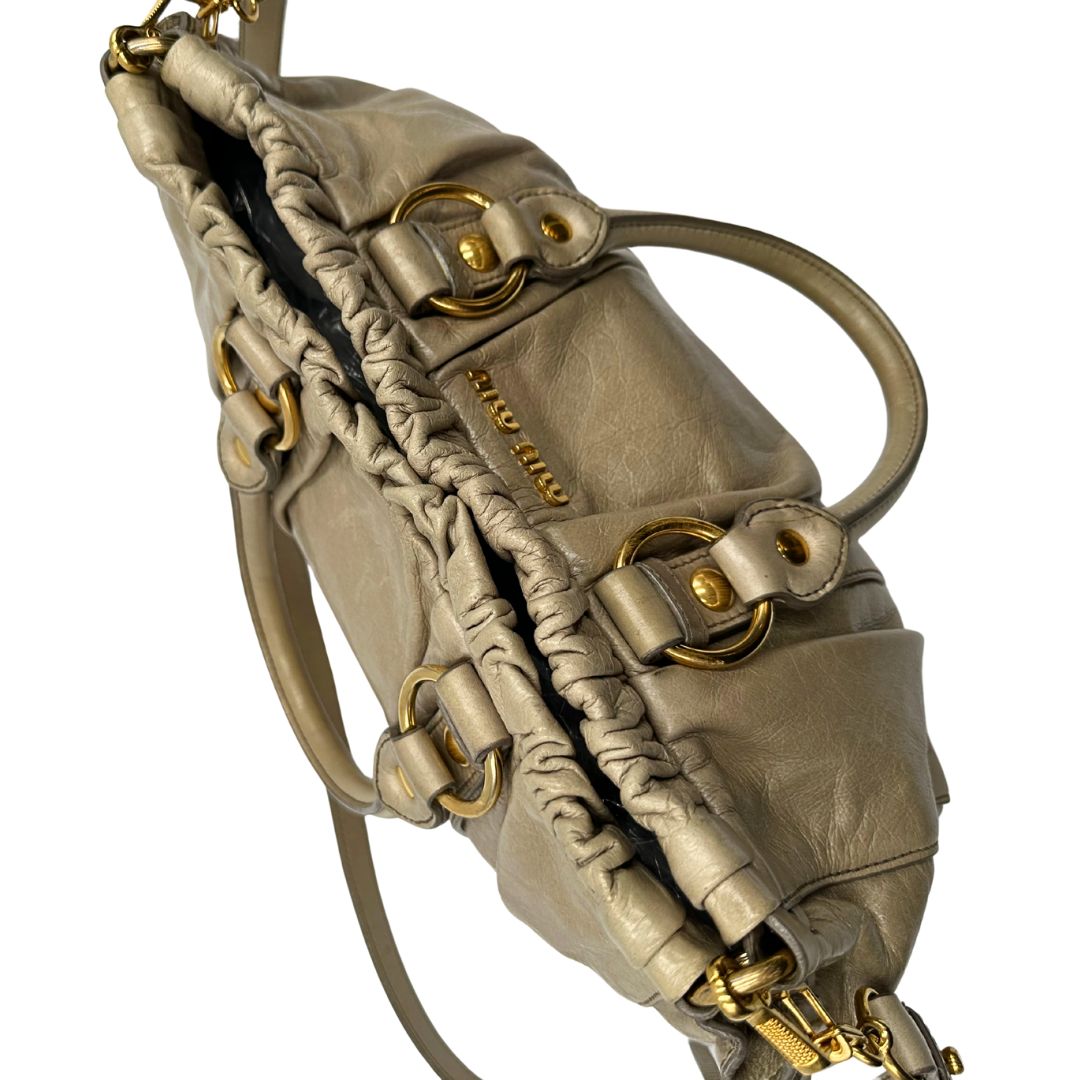 chiusura Borsa Miu Miu in pelle beige con parti metalliche dorate; munita di una tracolla e doppi manici stondati. Completa di dustbag, di lusso, originale, ottime condizioni. 