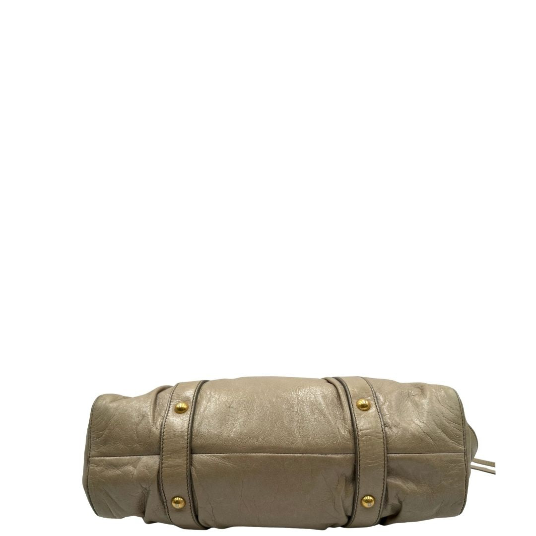 base Borsa Miu Miu in pelle beige con parti metalliche dorate; munita di una tracolla e doppi manici stondati. Completa di dustbag, di lusso, originale, ottime condizioni. 