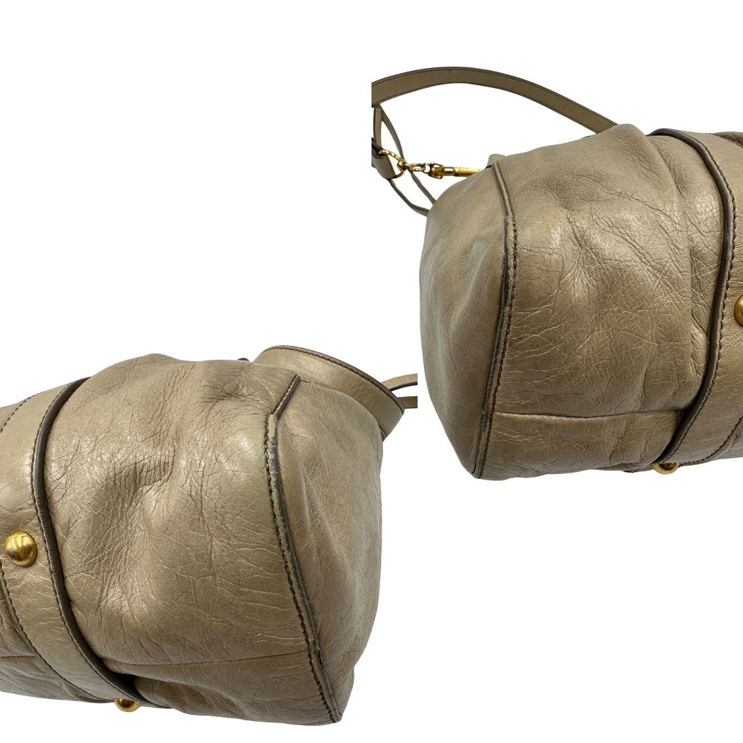 angoli Borsa Miu Miu in pelle beige con parti metalliche dorate; munita di una tracolla e doppi manici stondati. Completa di dustbag, di lusso, originale, ottime condizioni. 