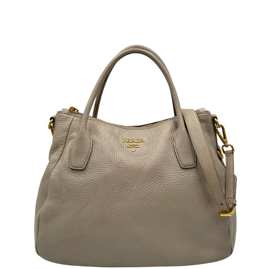 Front di una Borsa Tote Prada in pelle martellata color greige con parti metalliche dorate; munita di doppi manici stondati, una tracolla regolabile e amovibile. Originale, usata, di lusso, in ottime condizioni.