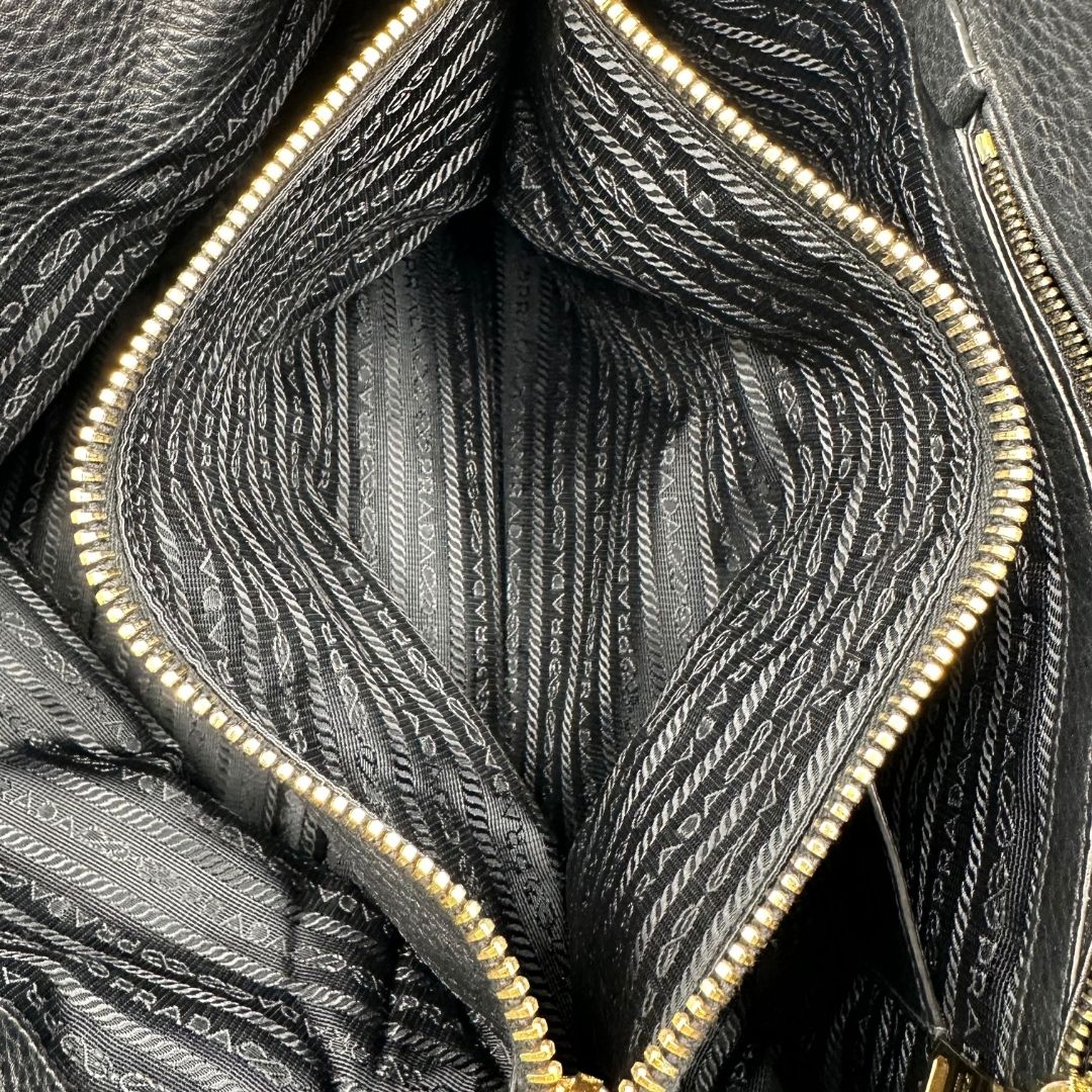 interno Borsa Prada in pelle martellata nera con parti metalliche dorate; munita di una tracolla amovibile e regolabile e doppi manici stondati, di lusso, originale, usata 