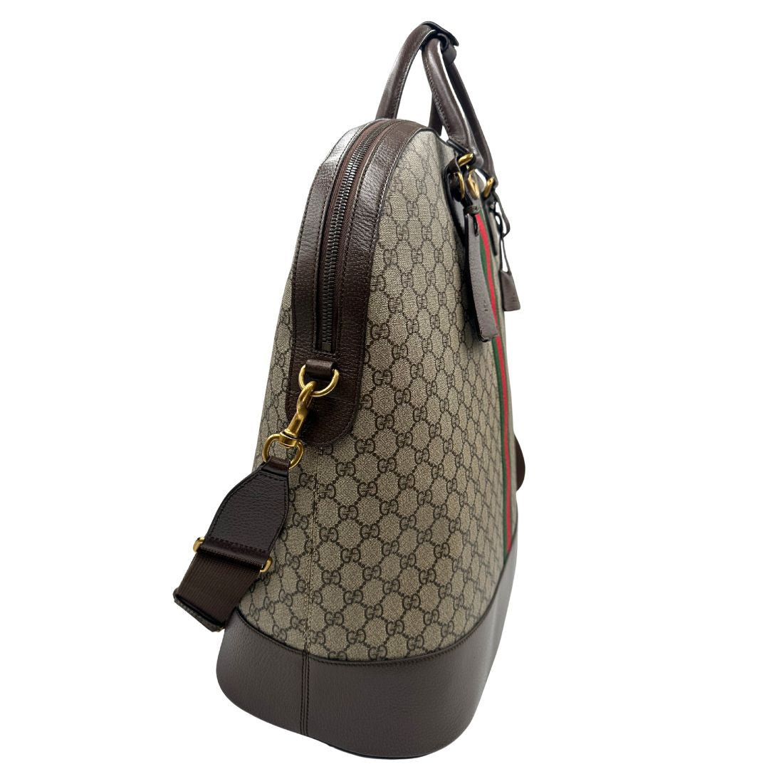 lato Borsone Gucci in canvas beige GG con finiture in pelle marroni e parti metalliche color oro anticato; impreziosito da iconica striscia Web rossa e verde; munito di doppi manici stondati e una tracolla amovibile regolabile in tessuto. Completo di dustbag, lucchetto e chiavi, di lusso, originale, ottime condizioni.