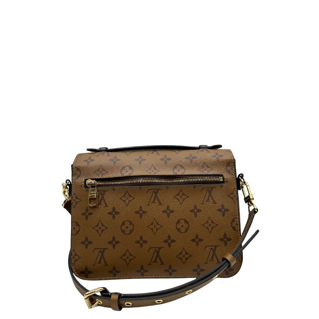 retro Borsa Louis Vuitton Métis in canvas marrone monogram reverse con parti metalliche dorate; munita di un manico singolo e una tracolla amovibile e regolabile. Completa di scatola, di lusso, originale, ottime condizioni, usata. 