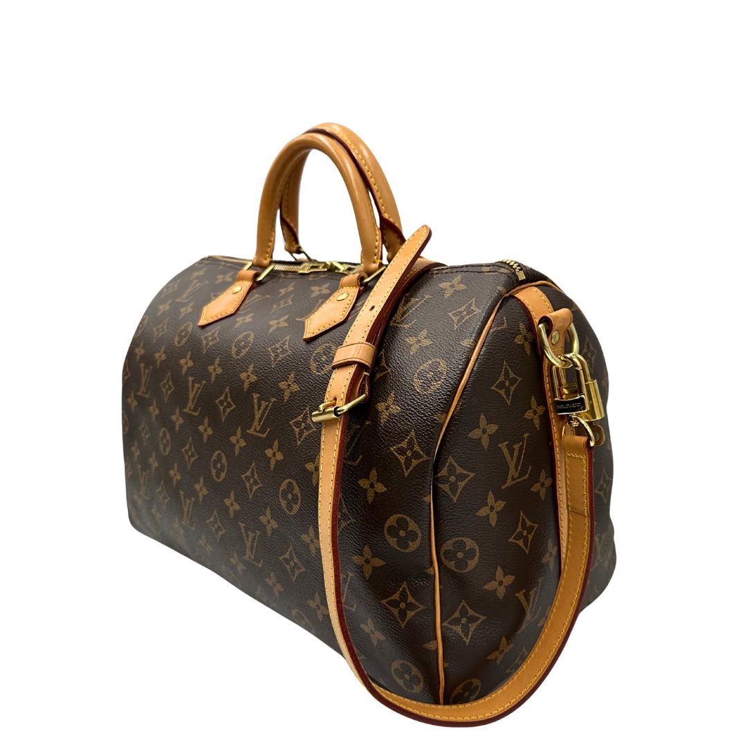 lato Borsa Speedy 35 in canvas marrone monogram con finiture in vacchetta naturale e parti metalliche dorate; munita di doppi manici stondati e una tracolla amovibile e regolabile. Completa di corredo, lucchetto e chiavi, di lusso, originale, ottime condizioni. 