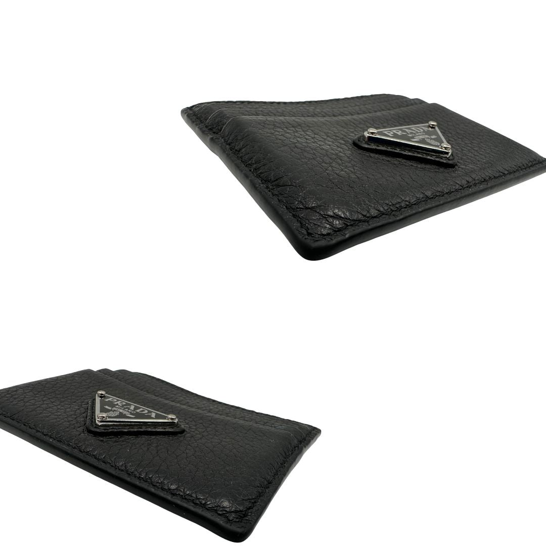 Portacarte Prada nera con parti metalliche argentate; impreziosito da iconico logo sul front. Completa di scatola, di lusso, originale, ottime condizioni, usato.