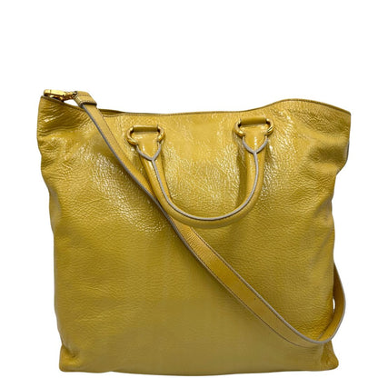 Retro di una Borsa Prada in pelle lucida color mustard con parti metalliche dorate; munita di un accessorio porta address e doppi manici stondati. Indossabile a mano oppure a tracolla. Originale, usata, di lusso, in ottime condizioni