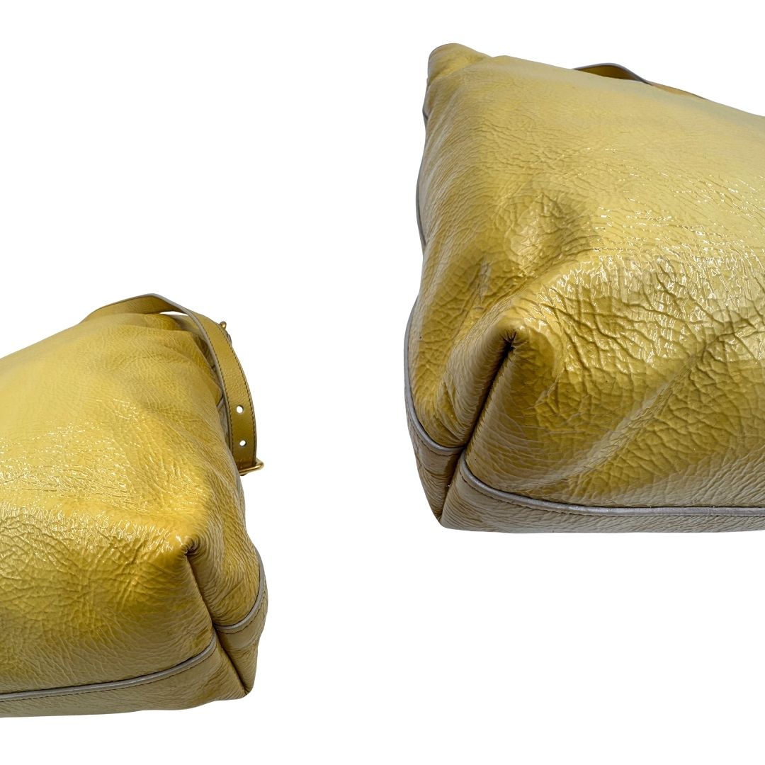 Angoli di una Borsa Prada in pelle lucida color mustard con parti metalliche dorate; munita di un accessorio porta address e doppi manici stondati. Indossabile a mano oppure a tracolla. Originale, usata, di lusso, in ottime condizioni