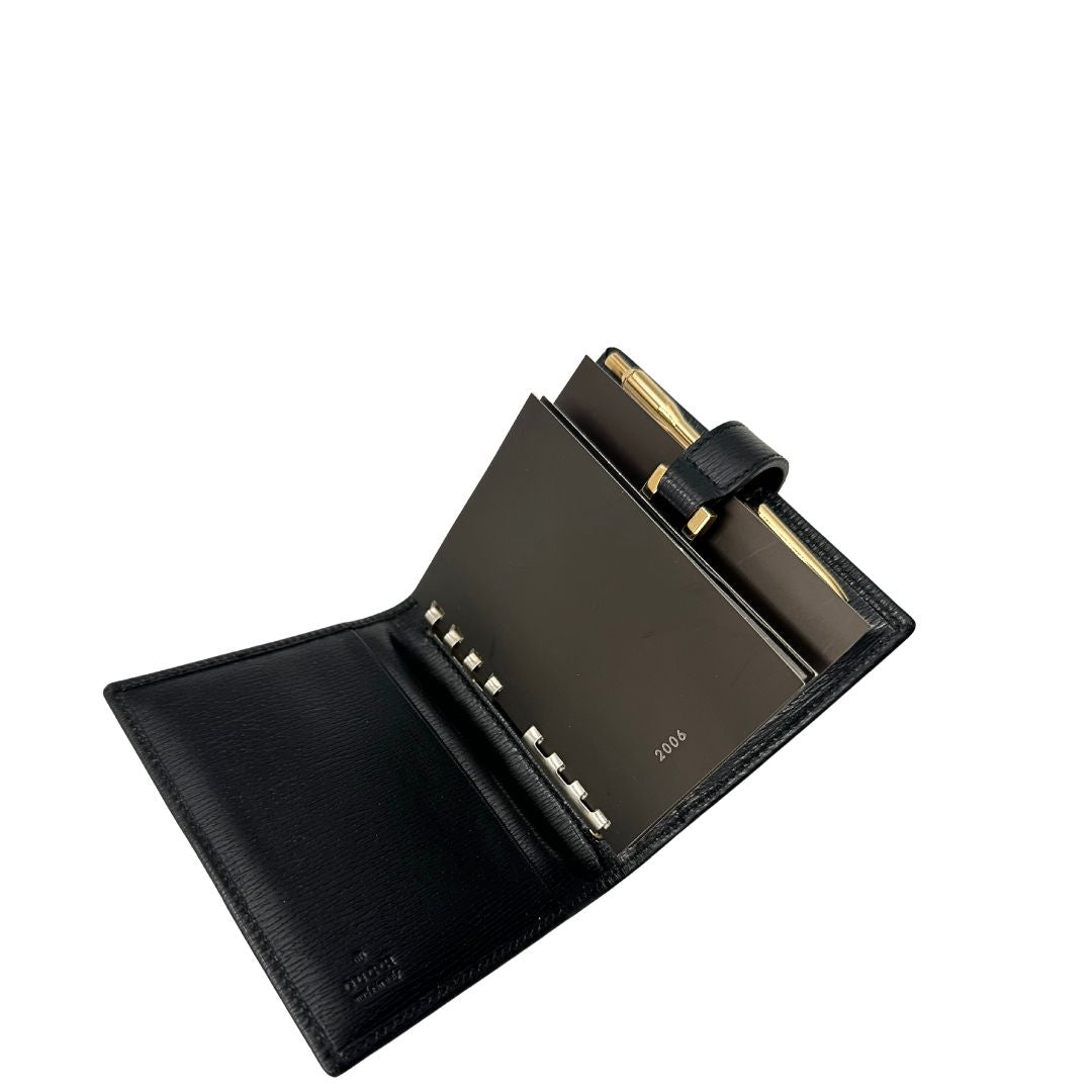 Agenda Gucci in pelle nera con parti metalliche dorate, munita di un pennino, di lusso, originale