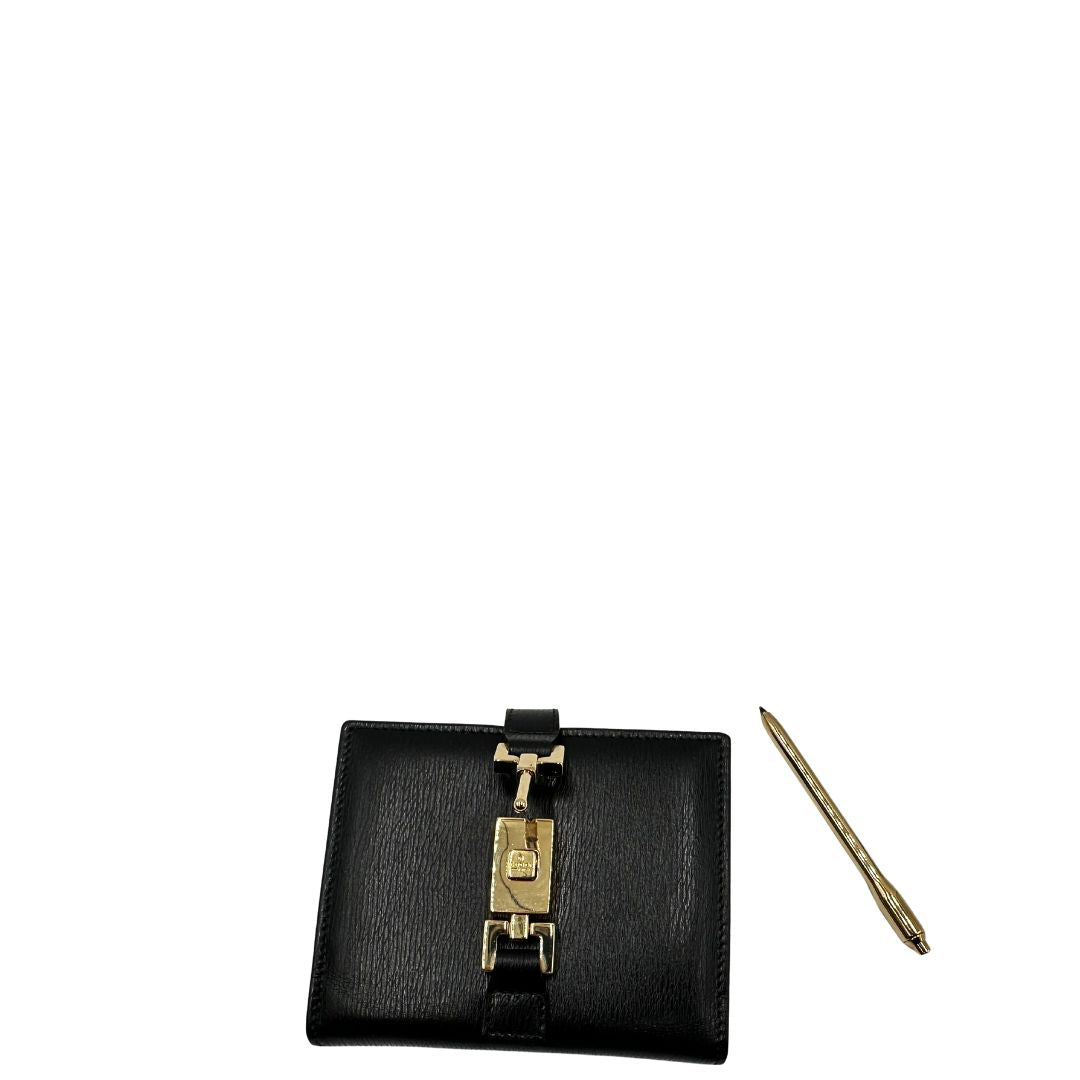 Agenda Gucci in pelle nera con parti metalliche dorate, munita di un pennino, di lusso, originale