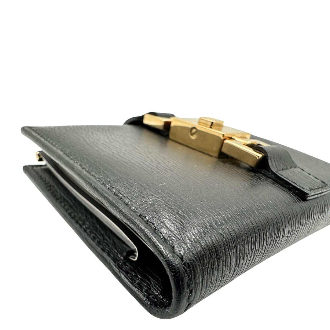 Agenda Gucci in pelle nera con parti metalliche dorate, munita di un pennino, di lusso, originale