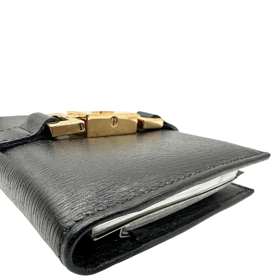 Agenda Gucci in pelle nera con parti metalliche dorate, munita di un pennino, di lusso, originale