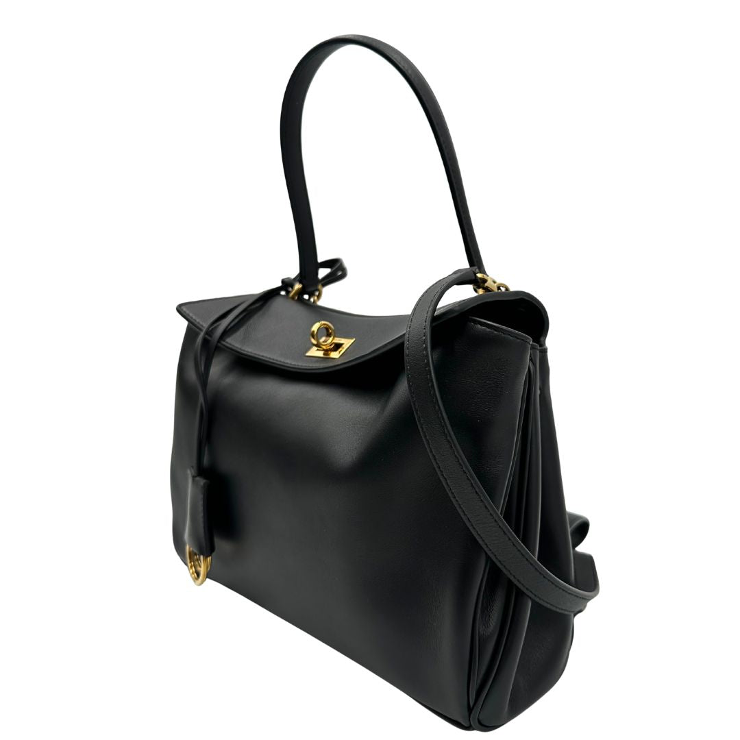 lato Borsa Balenciaga in pelle nera con parti metalliche dorate; munita di un manico singolo, una tracolla amovibile e una clochette portachiavi. Completa di dustbagm, di lusso, originale, ottime condizioni, usata. 