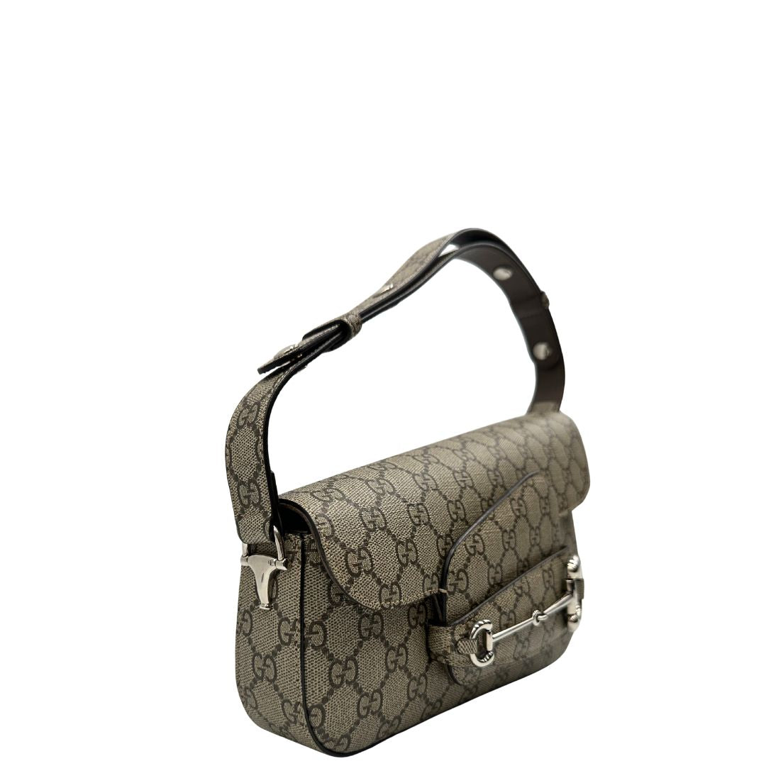 lato Borsa Gucci in canvas GG tortora con parti metalliche argentate; munita di un manico singolo leggermente allungabile; impreziosita da dettaglio Horsebit sulla chiusura e finiture in pelle marroni. Completa di dustbag, di lusso, originale, eccellenti condizioni, usata. 