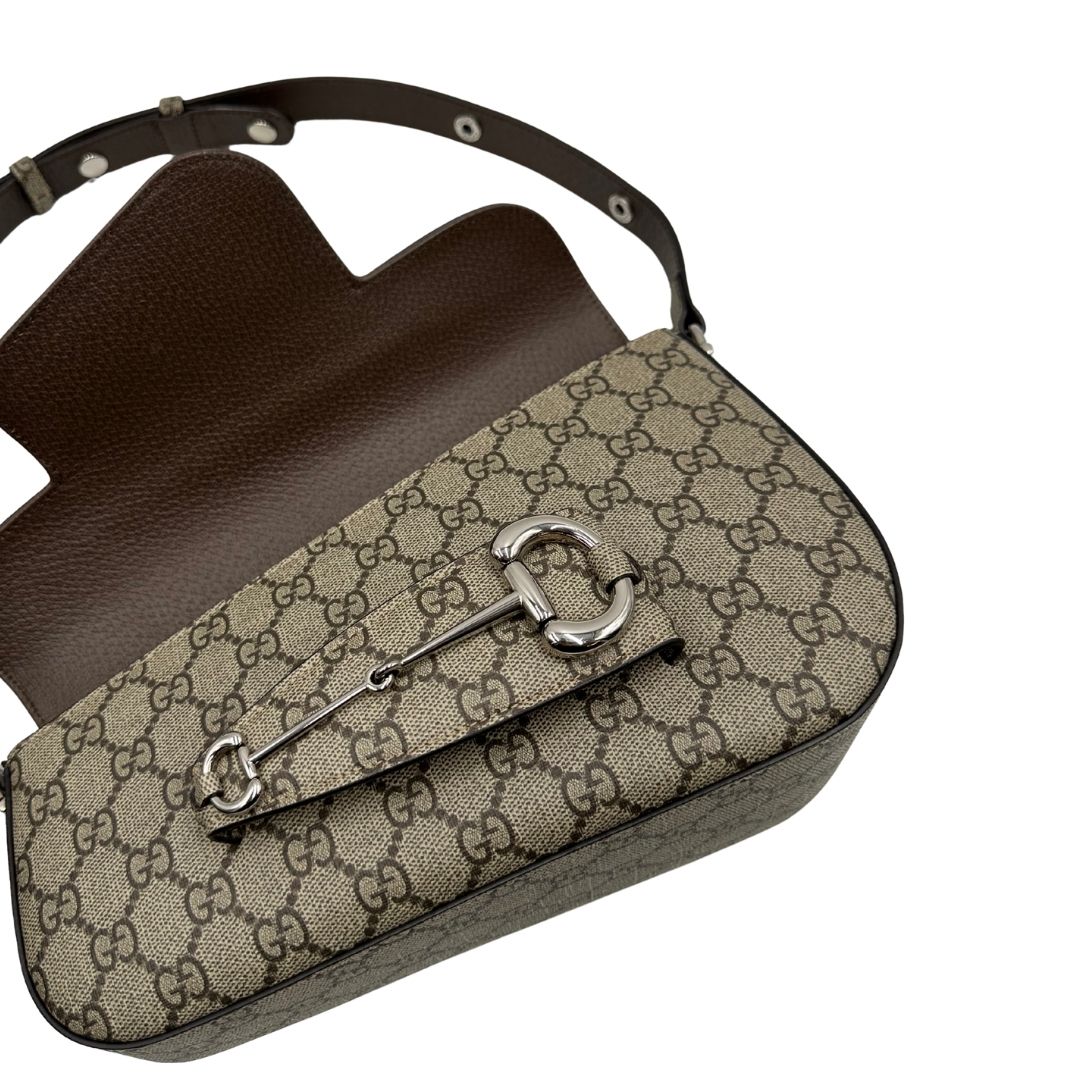 Borsa Gucci in canvas GG tortora con parti metalliche argentate; munita di un manico singolo leggermente allungabile; impreziosita da dettaglio Horsebit sulla chiusura e finiture in pelle marroni. Completa di dustbag, di lusso, originale, eccellenti condizioni, usata. 