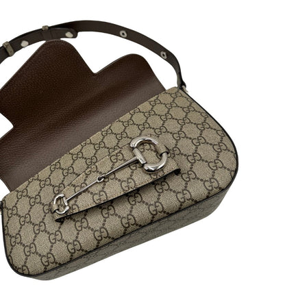 Borsa Gucci in canvas GG tortora con parti metalliche argentate; munita di un manico singolo leggermente allungabile; impreziosita da dettaglio Horsebit sulla chiusura e finiture in pelle marroni. Completa di dustbag, di lusso, originale, eccellenti condizioni, usata. 