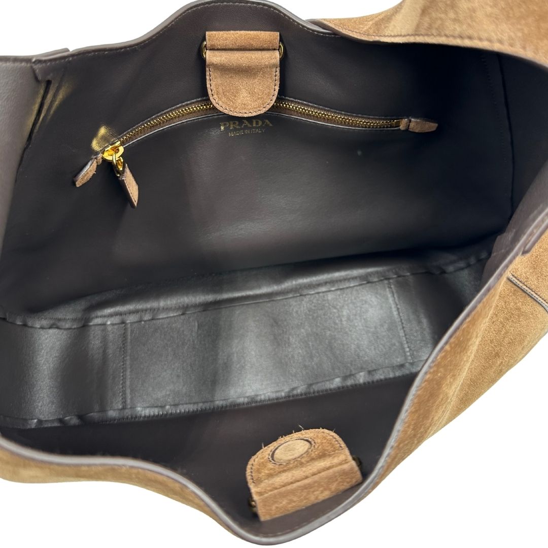 interno Borsa Prada in pelle scamosciata marrone con parti metalliche dorate; munita di un manico singolo regolabile; indossabile a spalla o a tracolla. Completa di dustbag, di lusso, originale, ottime condizioni, usata. 