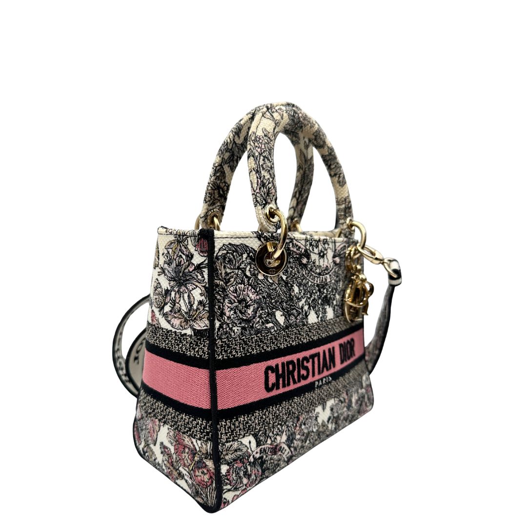 lato Borsa Dior in realizzata in tessuto jacquard con motivo Toile de Jouy nei toni del nero, beige e rosa e metalleria dorata, munita di due manici rigidi e una tracolla logata amovibile. Da indossare a tracolla o a mano. Completa di dustbag e cartellino, di lusso, usata, originale, ottime condizioni.