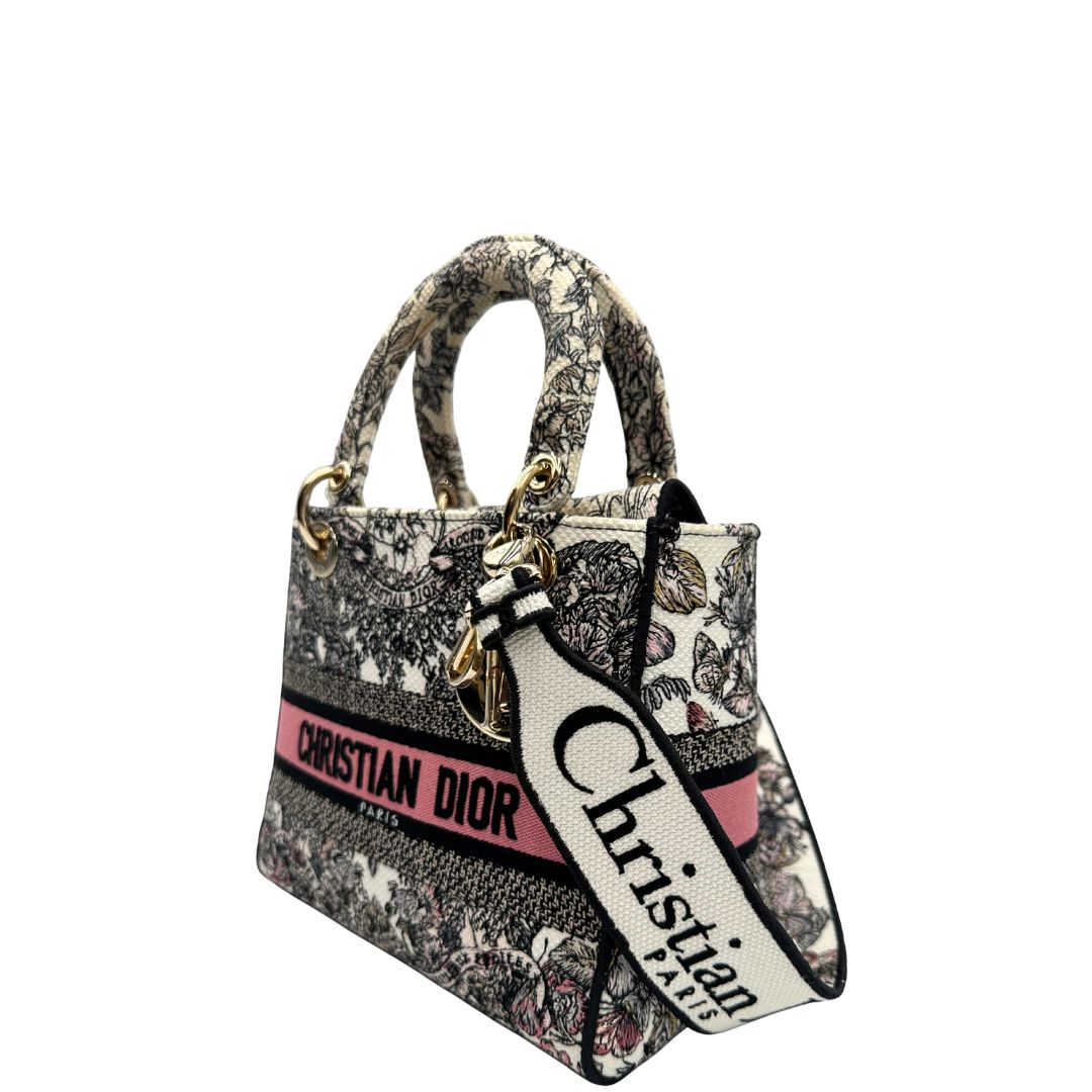 lato Borsa Dior in realizzata in tessuto jacquard con motivo Toile de Jouy nei toni del nero, beige e rosa e metalleria dorata, munita di due manici rigidi e una tracolla logata amovibile. Da indossare a tracolla o a mano. Completa di dustbag e cartellino, di lusso, usata, originale, ottime condizioni.