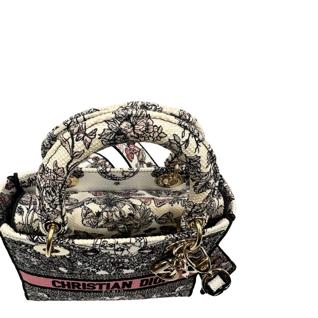 manico Borsa Dior in realizzata in tessuto jacquard con motivo Toile de Jouy nei toni del nero, beige e rosa e metalleria dorata, munita di due manici rigidi e una tracolla logata amovibile. Da indossare a tracolla o a mano. Completa di dustbag e cartellino, di lusso, usata, originale, ottime condizioni.