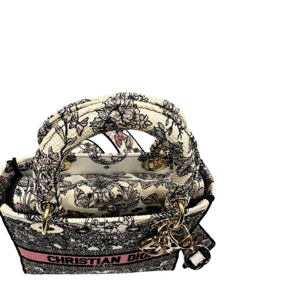 manico Borsa Dior in realizzata in tessuto jacquard con motivo Toile de Jouy nei toni del nero, beige e rosa e metalleria dorata, munita di due manici rigidi e una tracolla logata amovibile. Da indossare a tracolla o a mano. Completa di dustbag e cartellino, di lusso, usata, originale, ottime condizioni.