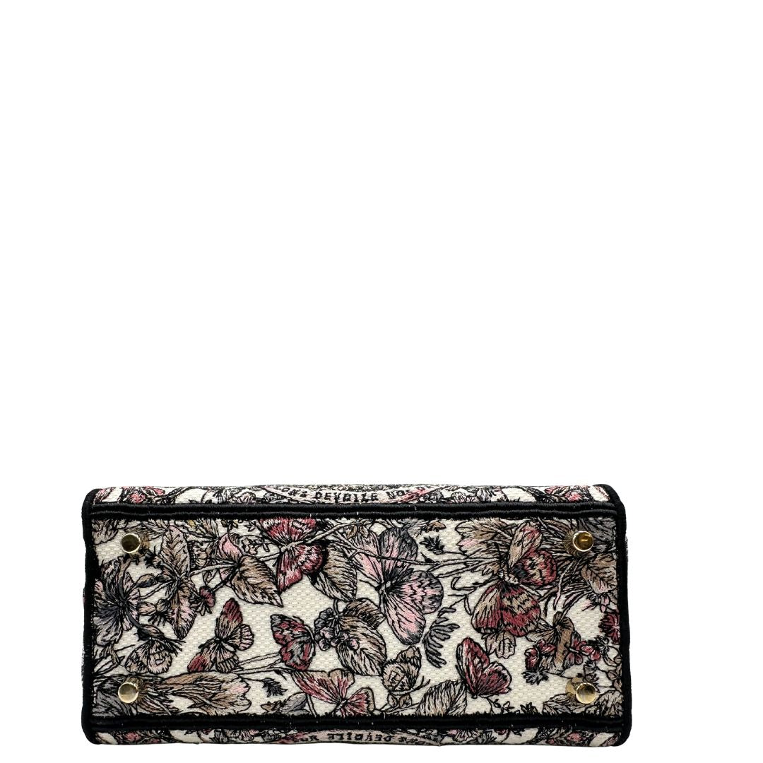 base Borsa Dior in realizzata in tessuto jacquard con motivo Toile de Jouy nei toni del nero, beige e rosa e metalleria dorata, munita di due manici rigidi e una tracolla logata amovibile. Da indossare a tracolla o a mano. Completa di dustbag e cartellino, di lusso, usata, originale, ottime condizioni.