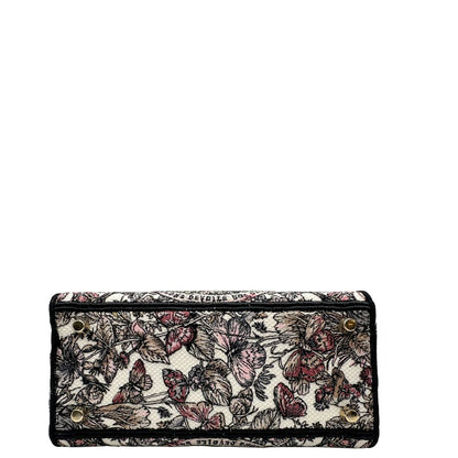 base Borsa Dior in realizzata in tessuto jacquard con motivo Toile de Jouy nei toni del nero, beige e rosa e metalleria dorata, munita di due manici rigidi e una tracolla logata amovibile. Da indossare a tracolla o a mano. Completa di dustbag e cartellino, di lusso, usata, originale, ottime condizioni.