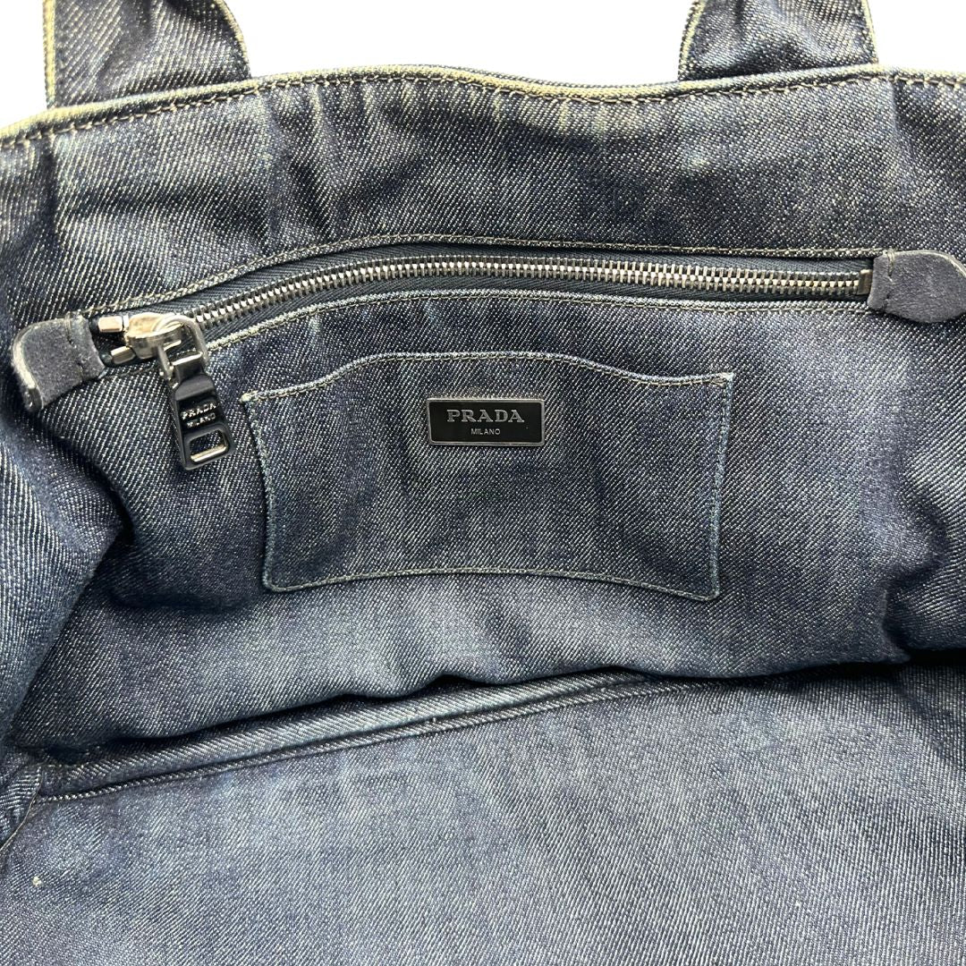 interno Borsa Prada in denim blu rifinita con borchie metalliche argentate; munita di una tracolla in tessuto regolabile e amovibile e doppi manici; indossabile a mano o a tracolla. Completa di dustbag, di lusso, originale, buone condizioni. 