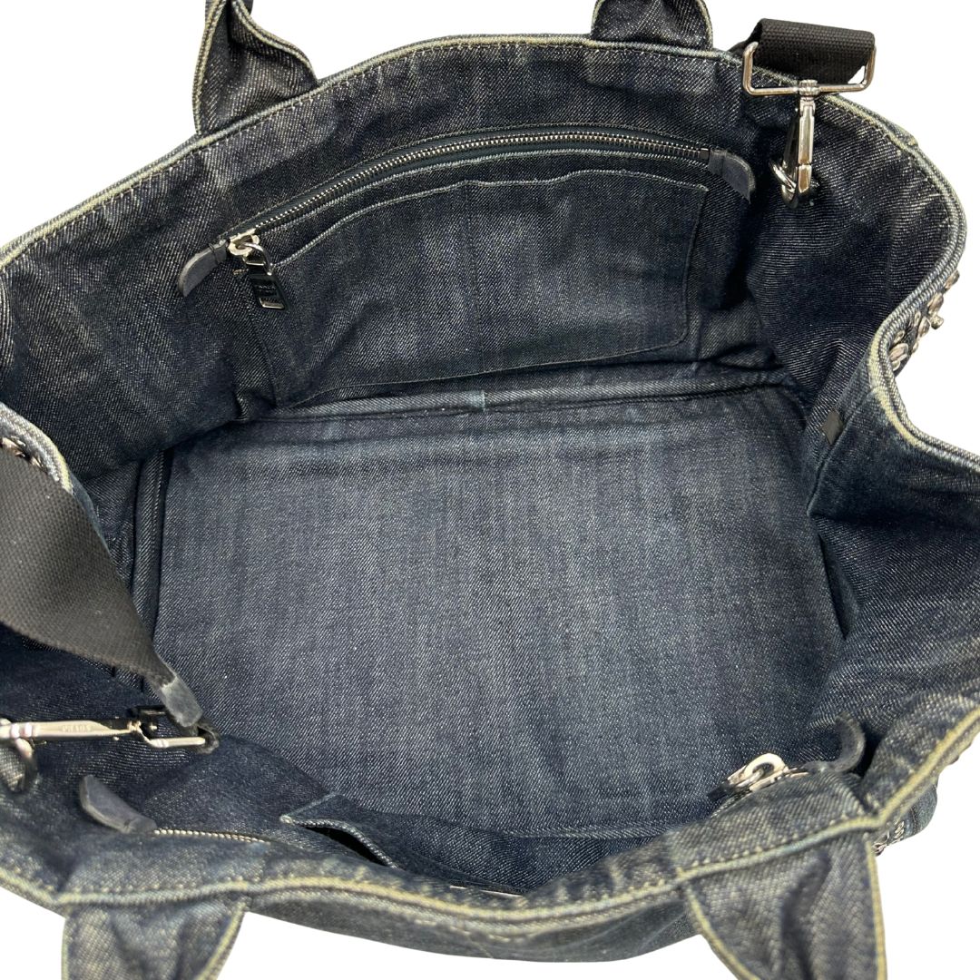 interno interno Borsa Prada in denim blu rifinita con borchie metalliche argentate; munita di una tracolla in tessuto regolabile e amovibile e doppi manici; indossabile a mano o a tracolla. Completa di dustbag, di lusso, originale, buone condizioni. 