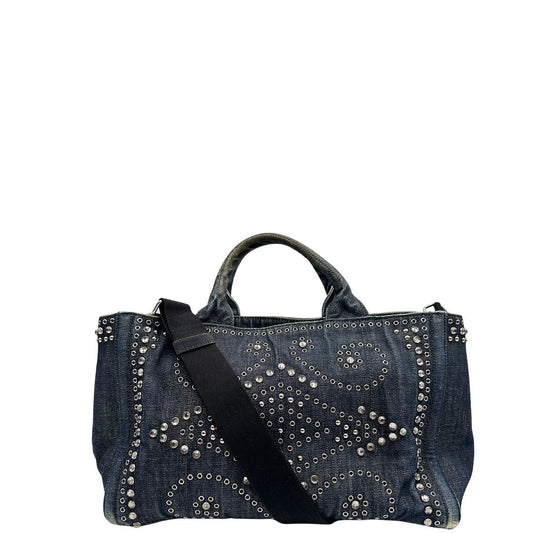 front Borsa Prada in denim blu rifinita con borchie metalliche argentate; munita di una tracolla in tessuto regolabile e amovibile e doppi manici; indossabile a mano o a tracolla. Completa di dustbag, di lusso, originale, buone condizioni. 