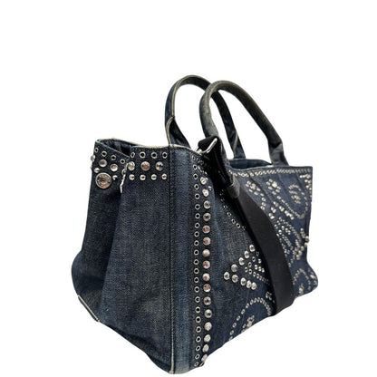 lato Borsa Prada in denim blu rifinita con borchie metalliche argentate; munita di una tracolla in tessuto regolabile e amovibile e doppi manici; indossabile a mano o a tracolla. Completa di dustbag, di lusso, originale, buone condizioni. 