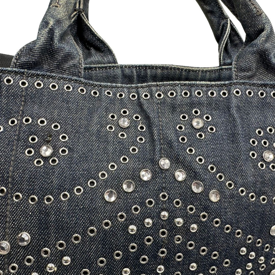 borchie Borsa Prada in denim blu rifinita con borchie metalliche argentate; munita di una tracolla in tessuto regolabile e amovibile e doppi manici; indossabile a mano o a tracolla. Completa di dustbag, di lusso, originale, buone condizioni. 