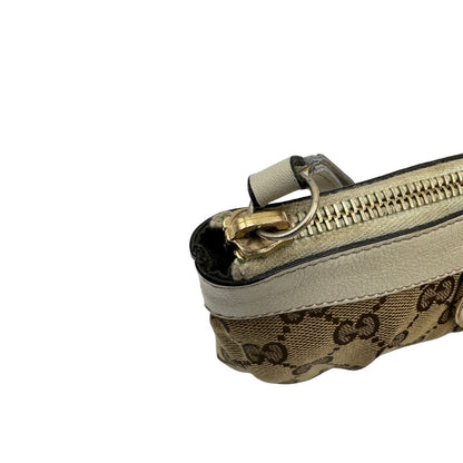 Chiusura di una Pochette Gucci in tessuto Gucci in tessuto GG beige con finiture in pelle bianca e parti metalliche dorate; munita di un polsino, da portare a mano. Completa di scatola. Originale, usata, di lusso, in ottime condizioni.