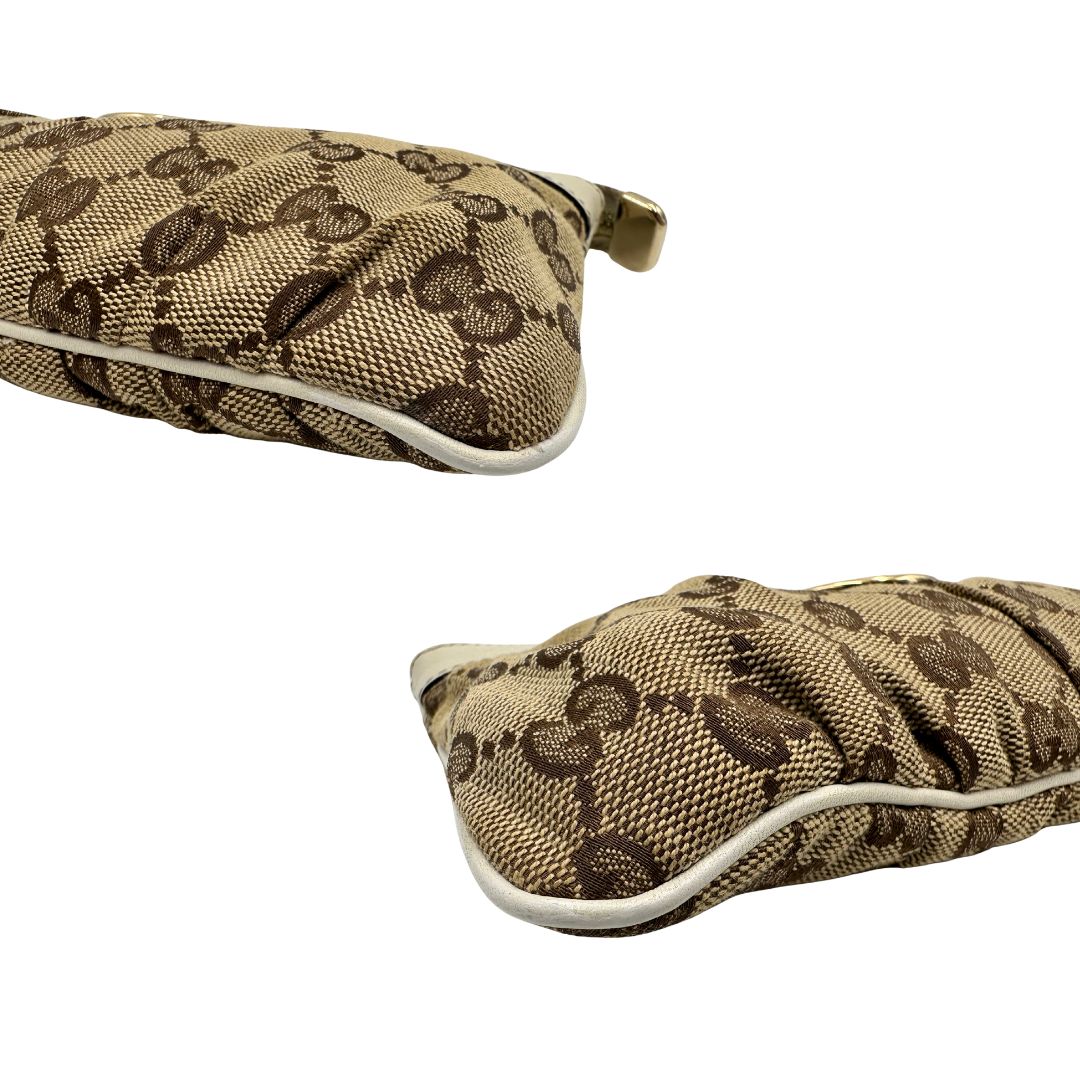 Angoli di una Pochette Gucci in tessuto Gucci in tessuto GG beige con finiture in pelle bianca e parti metalliche dorate; munita di un polsino, da portare a mano. Completa di scatola. Originale, usata, di lusso, in ottime condizioni.