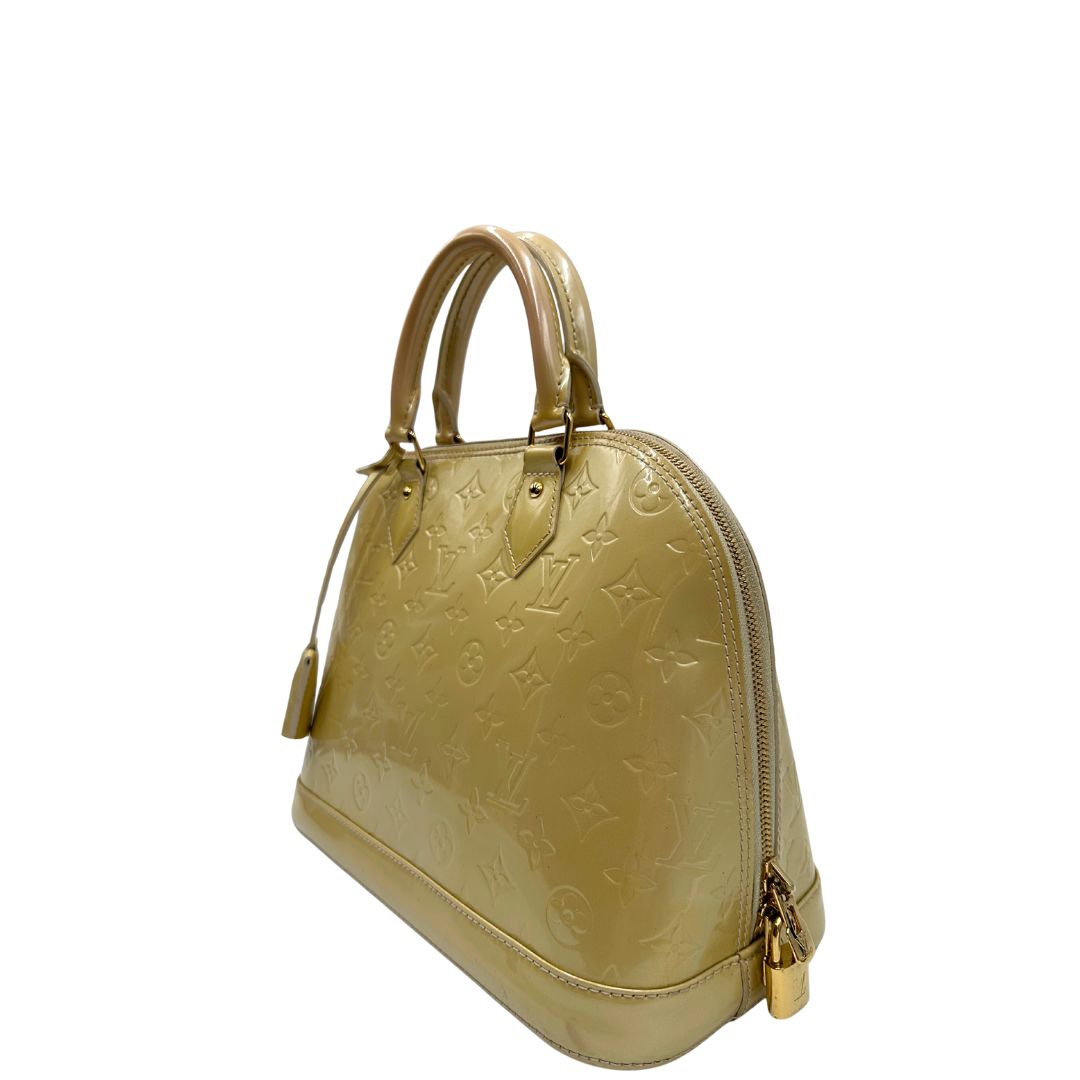 lato Alma PM Louis Vuitton in pelle Vernis color noisette con parti metalliche dorate e doppi manici stondati; da portare a mano. Completa di dustbag, lucchetto e chiavi, di lusso, originale, ottime condizioni, usata. 
