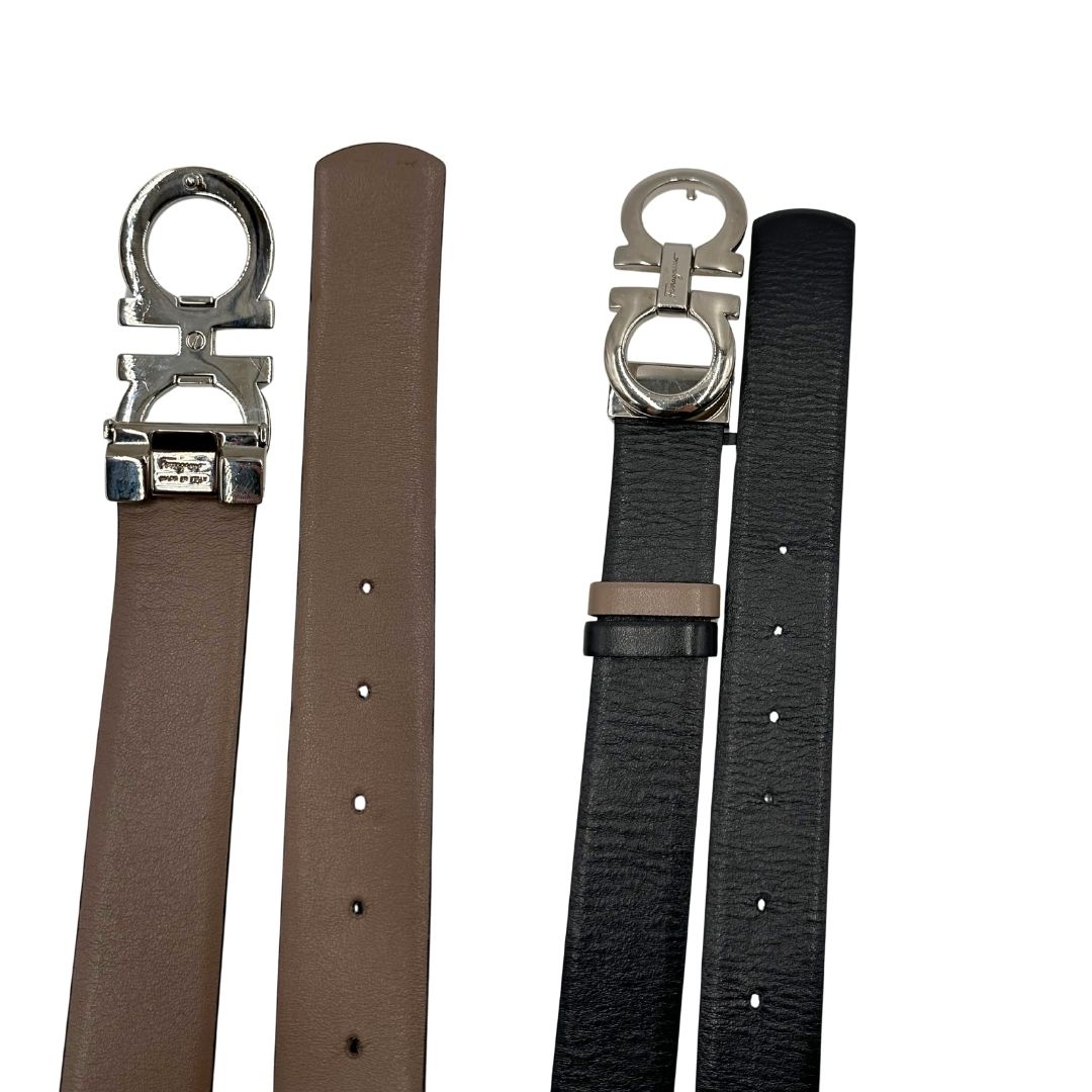 Cintura Gancini in pelle nera reversibile, con lato opposto color tortora e parti metalliche argentate, di lusso, originale, ottime condizioni, usata.