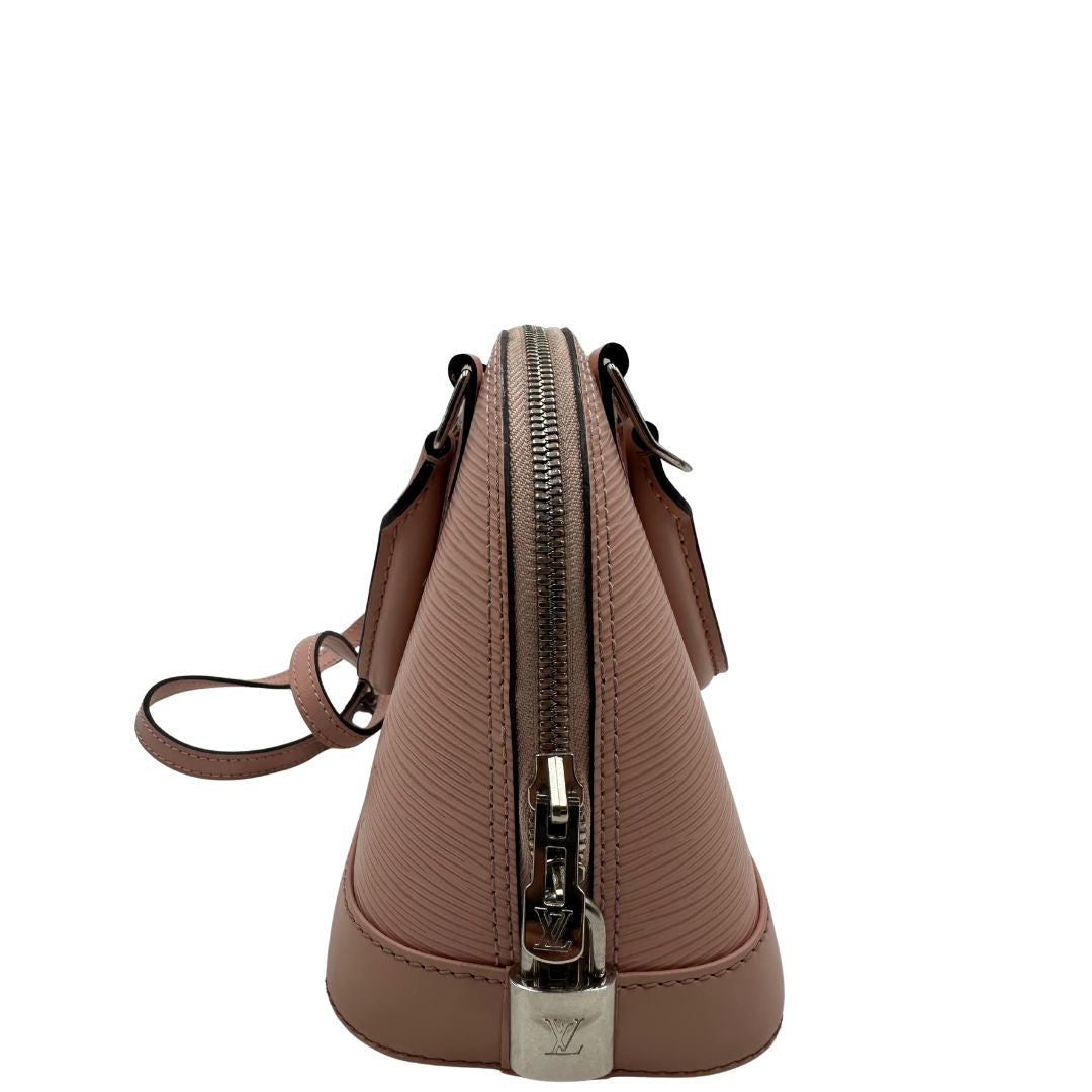 lato Borsa Louis Vuitton Alma BB in pelle epi rosa con parti metalliche argentate. Munita di doppi manici stondati e tracolla amovibile, dotata di clochette porta chiavi. Completa di lucchetto e chiavi, di lusso, originale, ottime condizioni. 