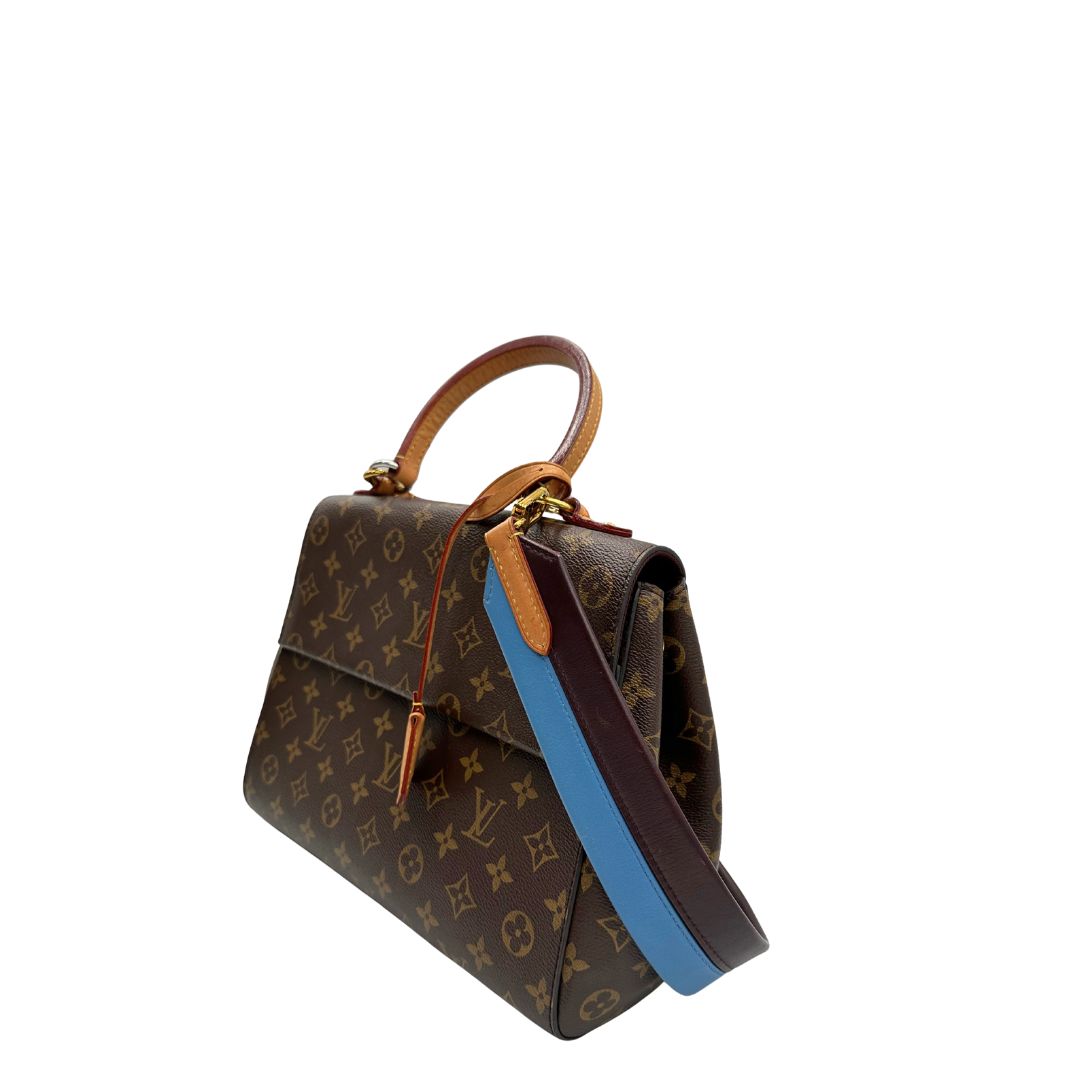 lato Borsa Louis Vuitton in canvas marrone monogram con finiture in vacchetta naturale e parti metalliche dorate; munita di un manico singolo e una tracolla bicolore, blu e marrone, amovibile. Completa di scatola, di lusso, originale, ottime condizioni. 