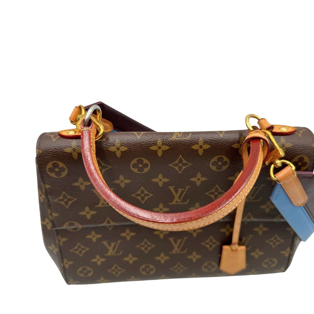 manico Borsa Louis Vuitton in canvas marrone monogram con finiture in vacchetta naturale e parti metalliche dorate; munita di un manico singolo e una tracolla bicolore, blu e marrone, amovibile. Completa di scatola, di lusso, originale, ottime condizioni. 
