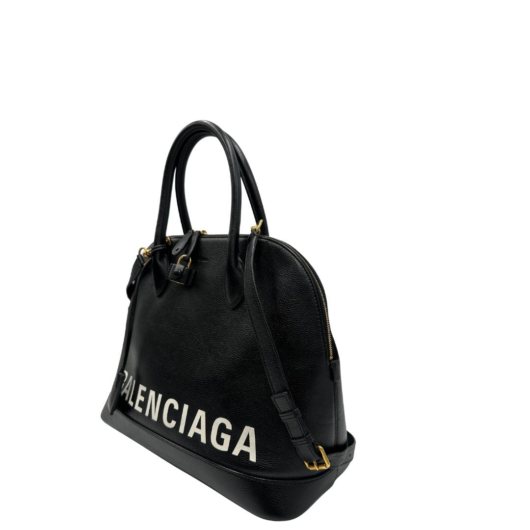 Lato sinistro di una Borsa Balenciaga in pelle martellata nera con parti metalliche dorate, munita di doppi manici e una tracolla amovibile e regolabile. Completa di dustbag e cartellini, lucchetto e chiavi. Originale, usata, di lusso, in ottime condizioni.