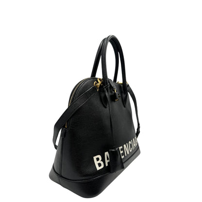 Lato destro di una Borsa Balenciaga in pelle martellata nera con parti metalliche dorate, munita di doppi manici e una tracolla amovibile e regolabile. Completa di dustbag e cartellini, lucchetto e chiavi. Originale, usata, di lusso, in ottime condizioni.