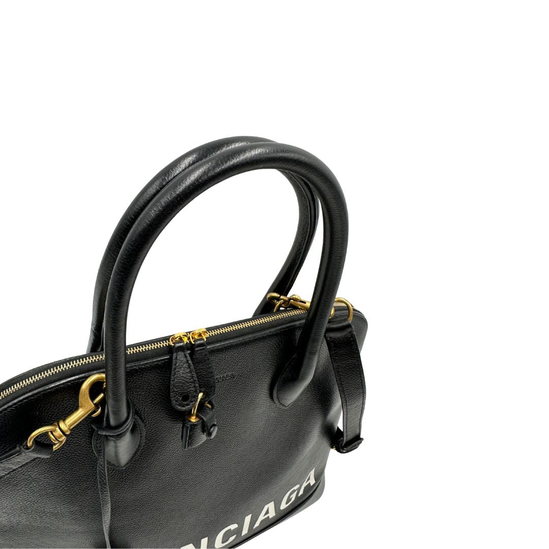 Manici di una Borsa Balenciaga in pelle martellata nera con parti metalliche dorate, munita di doppi manici e una tracolla amovibile e regolabile. Completa di dustbag e cartellini, lucchetto e chiavi. Originale, usata, di lusso, in ottime condizioni.